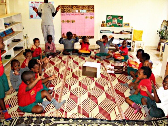 the mat, the class, holding some reams of paper.  (they were smiling bigger a second before, but my camera was a little slow)